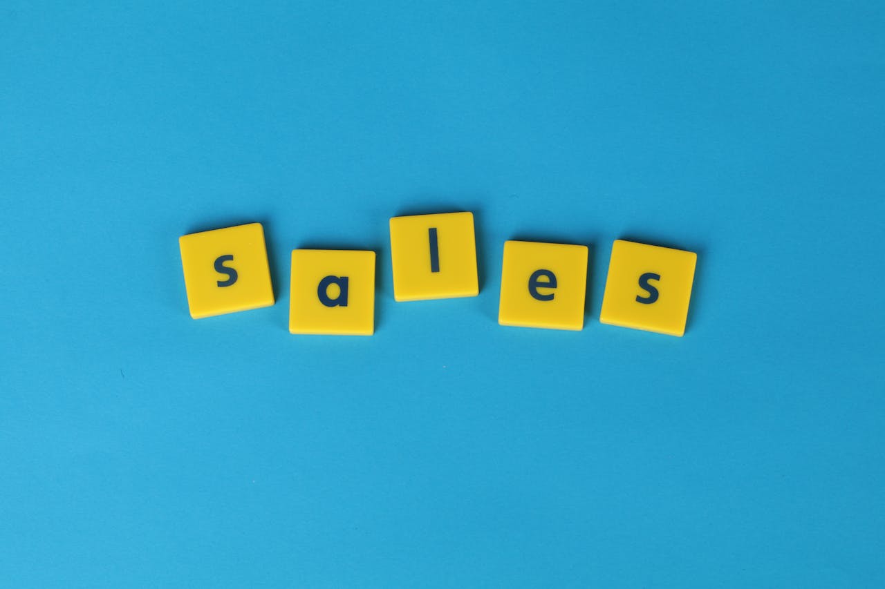 Yellow Scrabble tiles spelling sales on a vibrant blue background. Perfect for marketing and business themes.