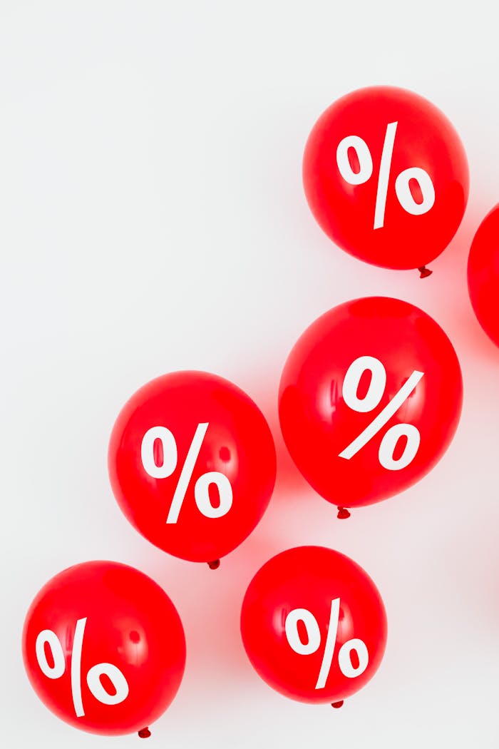 Red balloons featuring percentage symbols for sales and discounts on a white background.